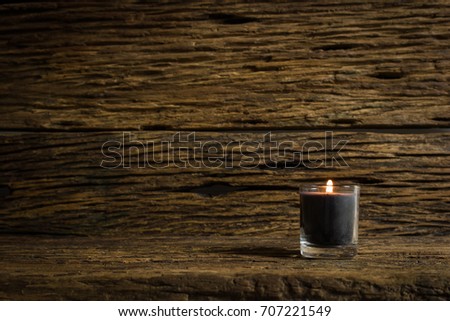 Candle on the old wooden floor in the dark. Selective focus.