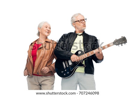 music, age and people concept - happy senior couple with electric guitar