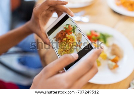 technology, eating and people concept - hands with smartphone photographing food at restaurant