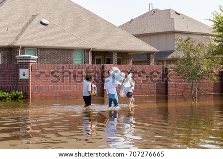 Residents in walk in high waters after devastating floods in Houston suburb Royalty-Free Stock Photo #707276665