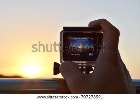 Sunset recording with a actioncam in the hand
