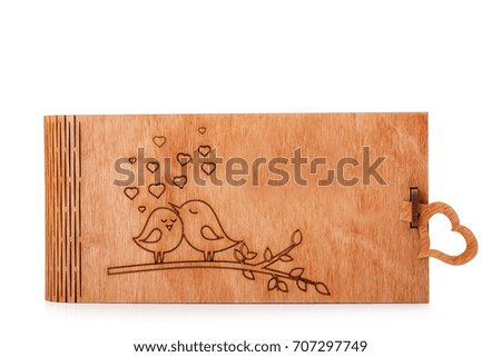 A cute, beautiful little wooden box with a lovely scorched picture isolated on a white background. A vintage, light brown wooden container for keeping toys, books or kids storage. Copy space.