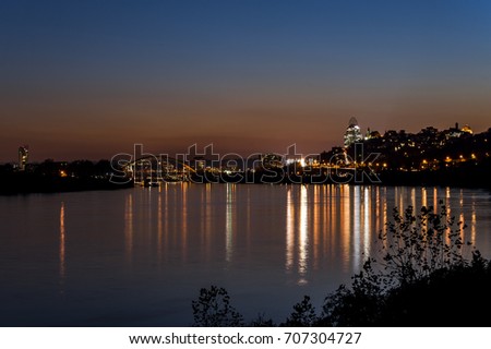 A view of the Cincinnati, Ohio skyline and the still waters of the Ohio River at sunset / blue hour.