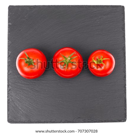 Ripe red tomatoes on black stone plate. Studio Photo