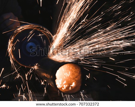 The working process. The worker cuts the pipes with a Angle grinder