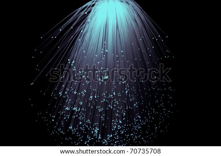 Violet and aqua coloured fibre optic light strands cascading down with a black background.