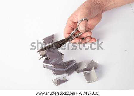 hand holding scissors cutting film stock