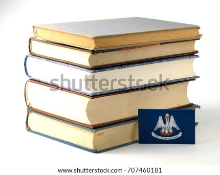 Louisiana flag with pile of books isolated on white background