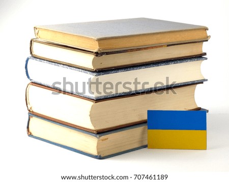 Ukraine flag with pile of books isolated on white background
