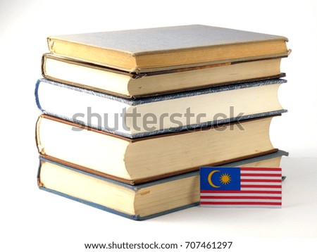 Malaysia flag with pile of books isolated on white background