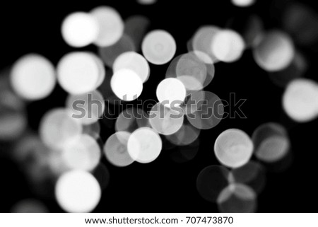 Abstract circular bokeh background of light in dining room. This image is burred or selective focus. Black and white picture.