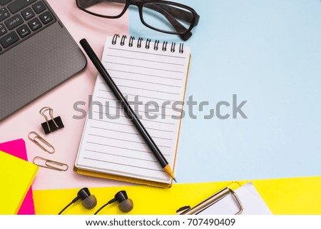 pencil and glasses on pink and blue background with copy space.