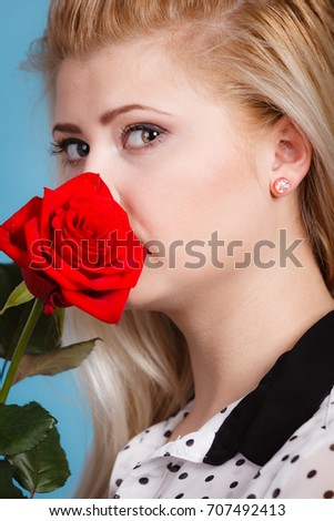 Gorgeous adorable woman holding red rose flower. Romantic portrait of beautiful young lady.