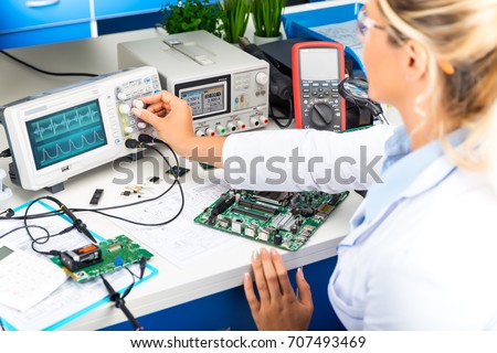 Young attractive female electronic engineer using digital oscilloscope in the laboratory Royalty-Free Stock Photo #707493469