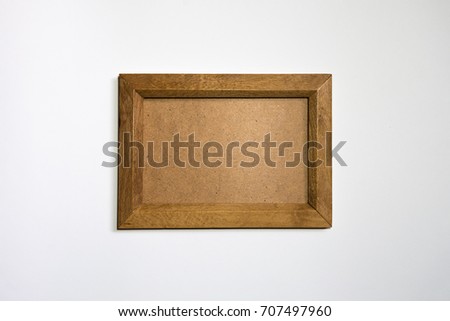 Empty wooden photo frame on wall