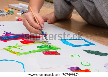 hand of children drawing Picture and shapes with colorful brush and paints