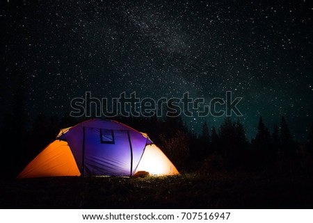 Campground for a starry night.
The tent glows under the night sky full of stars. milky way, galaxy.