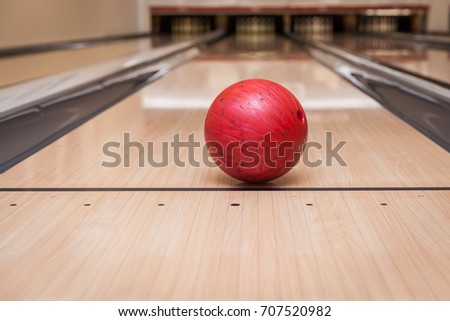 red bowling ball on the track in the bowling center