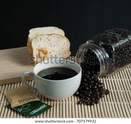 Coffee in cup and coffee beans on a wooden table