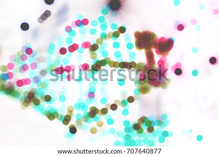 Rainbow blurred dotted on white background, colorful lighting black and blue backdrop. Abstract red green dappled spot foggy wallpaper. Gradient laser effect.