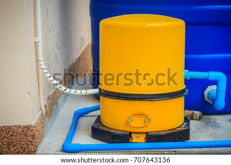House water supply system in the housing estate that composed with yellow automatic water pump. Royalty-Free Stock Photo #707643136