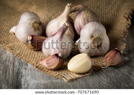 Close-up garlic bulbs and garlic cloves on wodeen background.