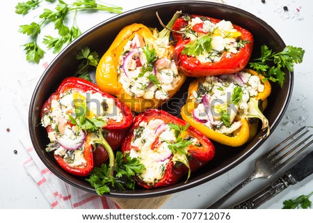 Red and yellow bell stuffed paprika peppers with cheese and herbs. Top view on white background. Royalty-Free Stock Photo #707712076