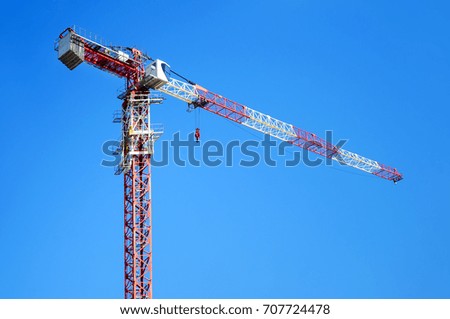 Construction crane. Red construction crane against a clear blue sky.