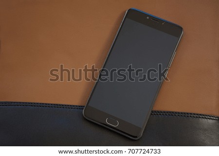 mobile phone on the brown leather bag