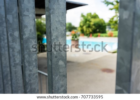 swimming bath seen through iron fence pool garden
