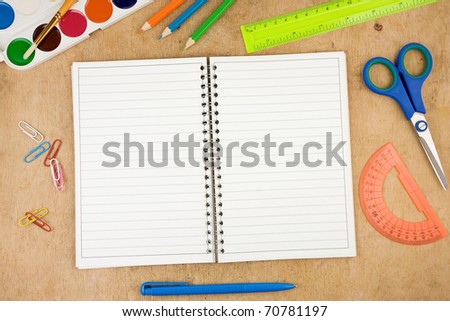 school accessories and checked notebook on wooden table