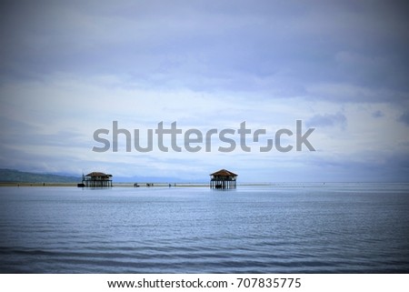 A small shelter standing in the middle of the sea. Photo taken in Manjuyod White Sandbar in Bais City, Philippines. Picture with vignette effects.