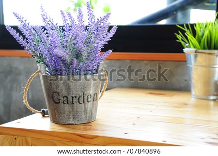 Artificial purple lavender flower in flowerpot on table with daylight