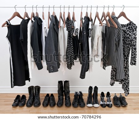 Female black and white clothes on a pole and shoes on a wooden floor. Royalty-Free Stock Photo #70784296