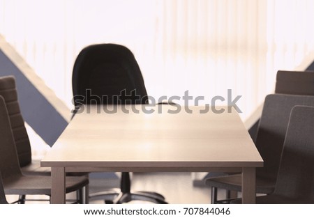 Empty wooden table and chairs in conference room