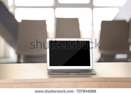 Modern laptop on table in conference room