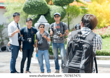 Traveller photographer. Asian tourist shooting group of friends in the temple.