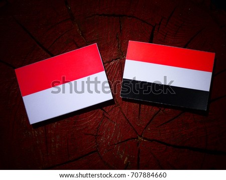 Indonesian flag with Yemeni flag on a tree stump isolated