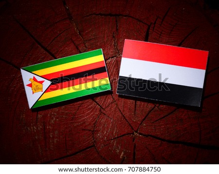 Zimbabwe flag with Yemeni flag on a tree stump isolated