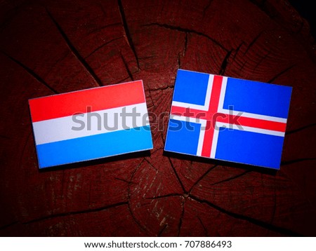 Luxembourg flag with Icelandic flag on a tree stump isolated