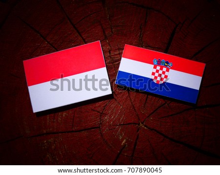 Indonesian flag with Croatian flag on a tree stump isolated