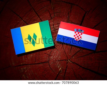 Saint Vincent and the Grenadines flag with Croatian flag on a tree stump isolated