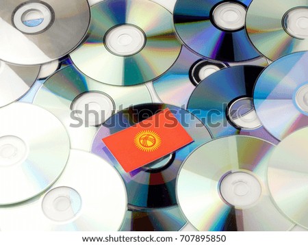 Kyrgyzstan flag on top of CD and DVD pile isolated on white