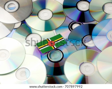 Dominica flag on top of CD and DVD pile isolated on white