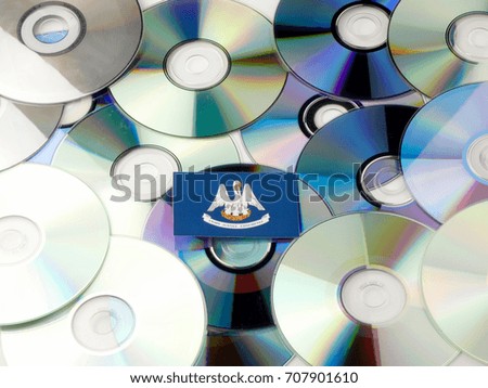 Louisiana flag on top of CD and DVD pile isolated on white