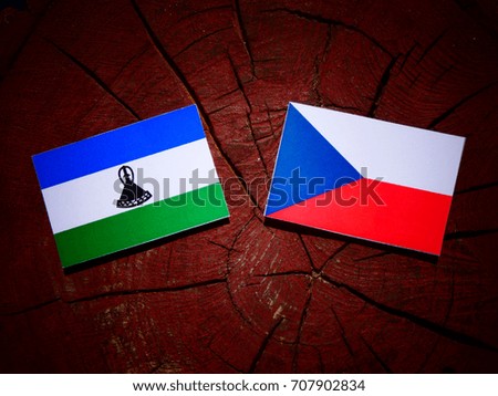 Lesotho flag with Czech flag on a tree stump isolated
