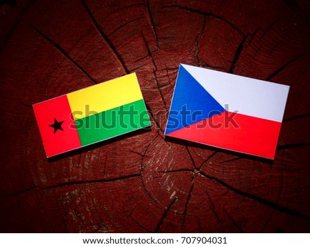 Guinea Bissau flag with Czech flag on a tree stump isolated