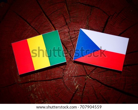 Guinean flag with Czech flag on a tree stump isolated