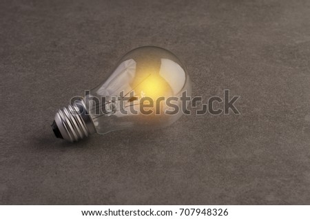 Glowing light bulb on granite background.as idea or energy concept.