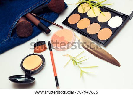Makeup  products and cosmetic beauty products spilling out from woman denim jeans